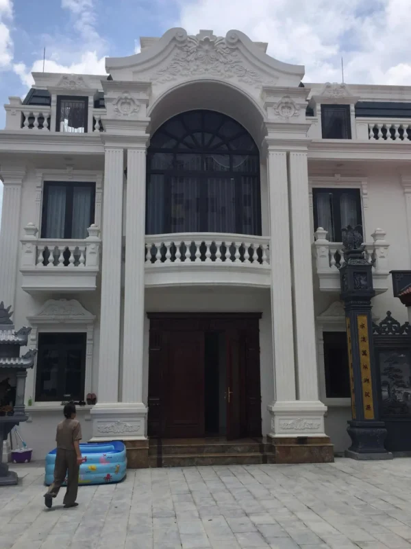 Biệt thự phong cách tân cổ điển có cửa sổ nhôm màu đen, ô cửa vòm lớn và ban công con tiện