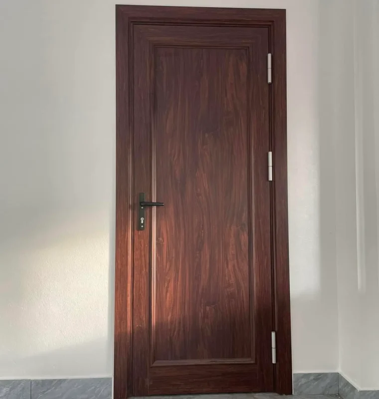 Cửa gỗ nhựa composite Thái Bình một ô nổi vân gỗ nâu đỏ, tay nắm đen, ba bản lề