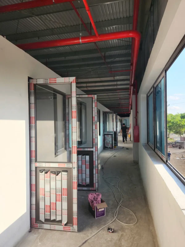 Hành lang bên trong có khung cửa nhôm kính đã gia công đang chờ lắp
