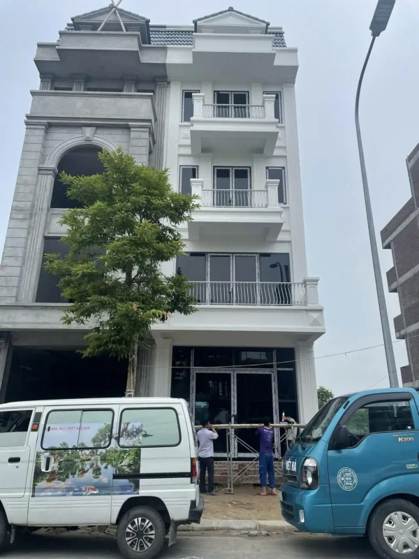 Xe tải xưởng nhôm kính Hưng Yên Việt Hà chở cửa đến công trình nhà phố, thợ đang lắp cửa tầng trệt